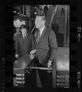 Governor Sargent going through a station turnstile while on a tour of the MBTA