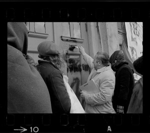A somewhat sheepish looking Joseph DeLeo, Cambridge health inspector and constable, approaches occupied building with an unfit-for-habitation notice
