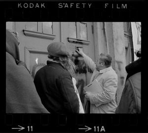 A somewhat sheepish looking Joseph DeLeo, Cambridge health inspector and constable, approaches occupied building with an unfit-for-habitation notice