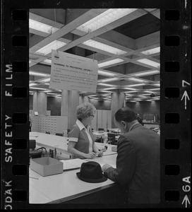 Teddy Green, reformed bank robber, filling out questionnaire while election clerk Ruth Kelly looks on
