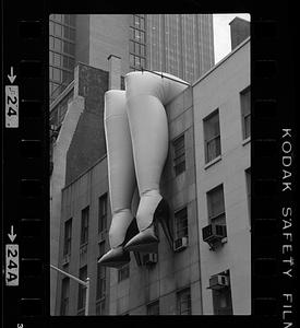 Inflatable legs hang from side of building, New York City