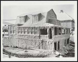 "Ice Palace" on Ocean Front. This summer house on Channel street at Hull, Mass., is completely covered with ice today (Jan. 23) formed from ocean spray. Some sections of this shorefront community south of Boston was inaundated when high tides followed in wake of blizzard Jan. 20.