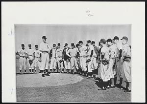 Here are Some of the 46 pitching rookies who reported to the Detroit Tigers at Tiger Town, near Lakeland, FLA., yesterday. On the mound is their pitching coach, Willis Hudlin. The Tigers' annual rookie baseball school will train 135 hopefuls during the two-week schooling.