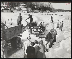Ice Cutting provides a nostalgic spectacle for townsfolk at Sunapee, N. H. Natural ice is still cut on Lake Sunapee and stores for summer sale. Power saws now do the actual cutting, however, and conveyer belts the lifting. Trucks, of course, do the hauling. At one time men and horses did the job.