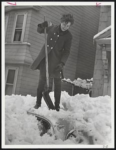 Marian Coleman of Armstrong street, Jamaica Plain, with an assist from six-year-old Donald Delphia, starts digging for what she hoped will be her car. Below: Success at last as the roof emerges.