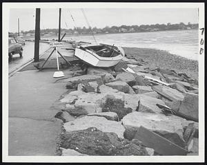 On The Rocks - This owner of this sloop, hurled on rocks at Houghs Neck by last night's storm, ought to have a good defense to a "no parking violation. Act of God defense, we calls it.