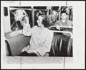 Buffalo, N.Y. – Smashed In Strike Violence – Martha Miller, 25, a Bell Aircraft employe, points to one of the windows smashed when the bus carrying 54 non-strikers to the plant in nearby Wheatfield was halted by a flying squad of strikers or sympathizers as violence flared in the 13-week-old dispute of CIO United Auto Workers for the second time in as many days this morning.