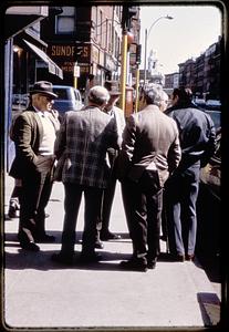 A group of men standing on the corner of Hanover and Parmenter Streets, North End, St. Stephen's in the far background