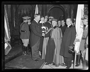 James M. Curley shaking hands with an unidentified member of the clergy