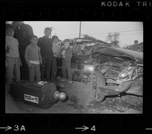 People with wrecked car and toppled fire box