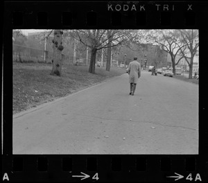Mayor Kevin White walking down street outside a park