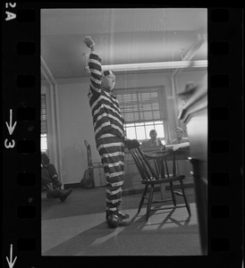 Man in striped prisoner costume addresses Massachusetts legislative committee