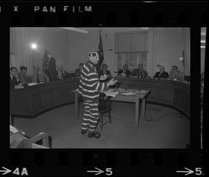 Man in striped prisoner costume addresses Massachusetts legislative committee