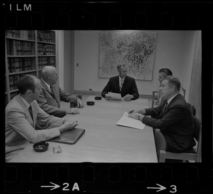 Five unidentified men around a conference table