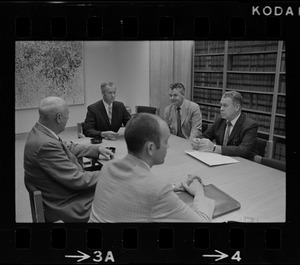 Five unidentified men around a conference table