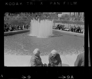 Two women sitting on fountain at City Hall Plaza