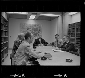 Five unidentified men around a conference table