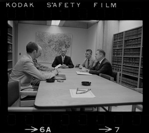 Five unidentified men around a conference table