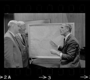 Boston Mayor Kevin White examines hurricane chart with two unidentified men