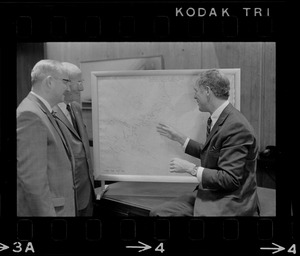 Boston Mayor Kevin White examines hurricane chart with two unidentified men