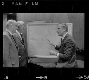 Boston Mayor Kevin White examines hurricane chart with two unidentified men