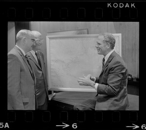 Boston Mayor Kevin White examines hurricane chart with two unidentified men
