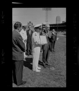 Dick O'Connell, general manager of Red Sox, accepts citation from Rear Adm. Richard Fowler, chief of Naval Air Reserve Training, at Fenway Park, honoring Tom Yawkey for patriotism and generosity to servicemen