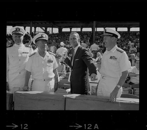 Unidentified man with naval officers throwing ceremonial first pitch at Fenway Park