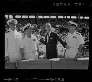 Unidentified man with naval officers throwing ceremonial first pitch at Fenway Park