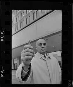 Former Massachusetts Lieut. Gov. Francis Bellotti at Government Center holding 47 cent key he claims will open any filing cabinet