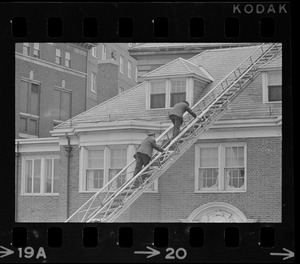 Police using fire department ladder truck to look for escapees from Charles Street Jail on a roof