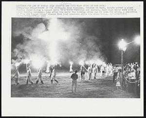 Burning of the Cross--Ku Klux Klansmen, torches in hand, parade around a giant flaming cross during a recent rally in a North Carolina cow pasture. Each Klan rally ends with a cross burning ceremony. Long after the rally the burning cross can be seen for miles. A recording of “The Old Rugged Cross” blares from loud speakers while the cross burns.