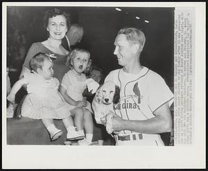 Shows Dog to Family- Red Schoendienst, Cards second baseman, shows puppy pointer to his family after it was presented him as a gift during pre-game ceremony at Busch stadium last night. With his wife are his daughters Cathleen, 10 month and Colleen, 2. Among other gifts was a Lincoln sedan. Schoendienst celebrated his "night" by hitting a single, double and triple.