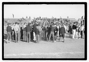 A crowd of people by bleachers