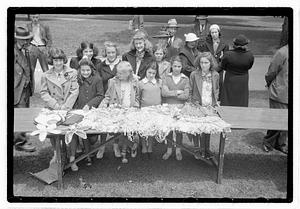 A group of girls behind a collection of sewn items