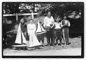 Boys holding model sailboats
