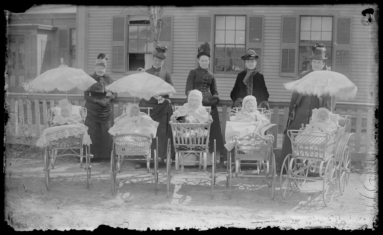Group with babies in old fashioned prams, poss. nr a church or lg bldg