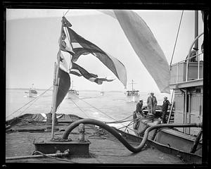 Flags flying by a docked boat