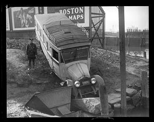 A police officer stand next to a wrecked vehicle