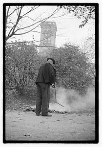 A man raking and burning leaves