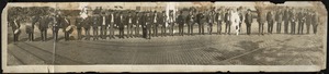 Men in uniforms standing on cobblestone street