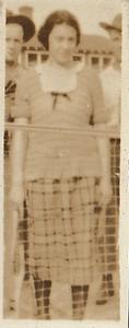 Unidentified woman and two men standing behind a sports net