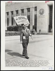 He Approves--Pickets who protested Monday's Congressional hearing into Communist activities in the film industry didn't show up yesterday. They were replaced in front of the Federal Building, scene of the House Un-American Activities Committee meetings, by this lone picket. His sign read: "I approve of this hearing. Keep smoking out Communists." He gave his name as "John Doe, American."