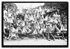 Boys holding model sailboats