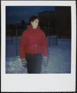 Young person wearing a red jacket and mittens