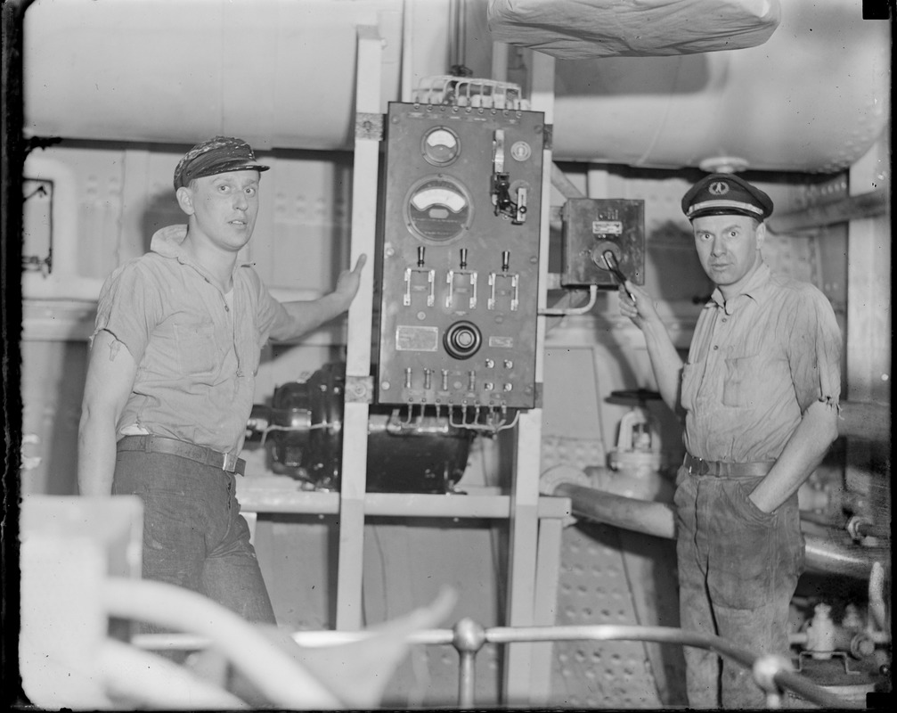 Nantucket lightship no. 117 interior. R-R Harry C. Gifford and William W. Perry at Panel that operates air oscillator fog signal. Takes 12 1/2 amps to sound horn.