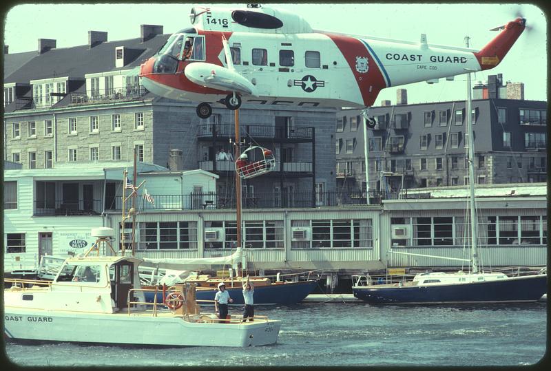 Coast Guard helicopter lifting man off Coast Guard boat, Boston Harbor