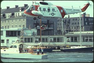 Coast Guard helicopter lifting man off Coast Guard boat, Boston Harbor