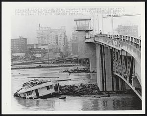 A houseboat and hundreds of logs swept downstream on the Willamette River come to rest against the piers of the Morrison Bridge in downtown Portland.