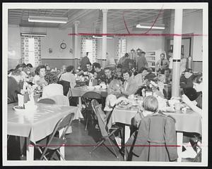Enjoying the Army's Hospitality, Winthrop residents forced to abandon their homes at high tide yesterday morning dine at the Fort Banks mess hall following their evacuation by Army personal.